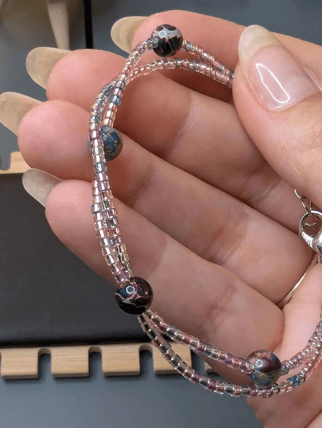 Bracelet torsadé rose, bleu, et violet avec des perles Miyuki en verre, des perles naturelles. Le fermoir est de couleur argenté.