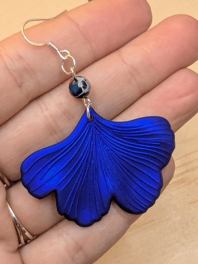 Boucles d'oreilles avec pendentifs en forme de feuilles de couleur bleu métallisé et des perles de jaspe sédiment de mer. 
