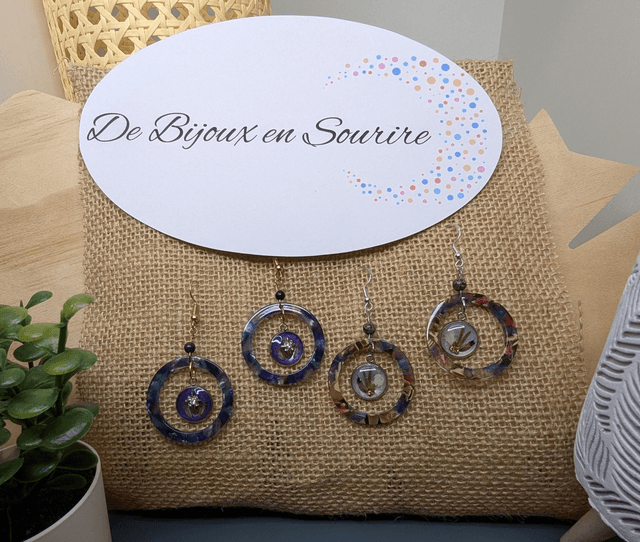 Boucles d'oreilles avec 2 pendentifs, cercle en résine coloré bleu violet, avec des fleurs séchées, des perles naturelle et un fermoir en or. 