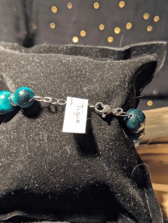 Bracelet en perles d'œil de tigre bleu et des perles d'espacement plate en argent. Le fermoir et la chaine fermoir sont en argent.