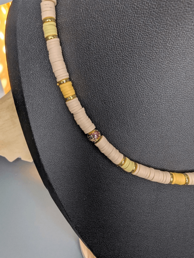 collier ras de cou avec des perles plates heishi de couleurs jaune, beige et or intercalé de perles de lave volcanique doré. 