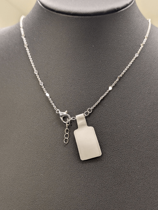 Collier court avec une chaine de couleur argent, un pendentif avec carré en résine et un cercle en métal argenté. 