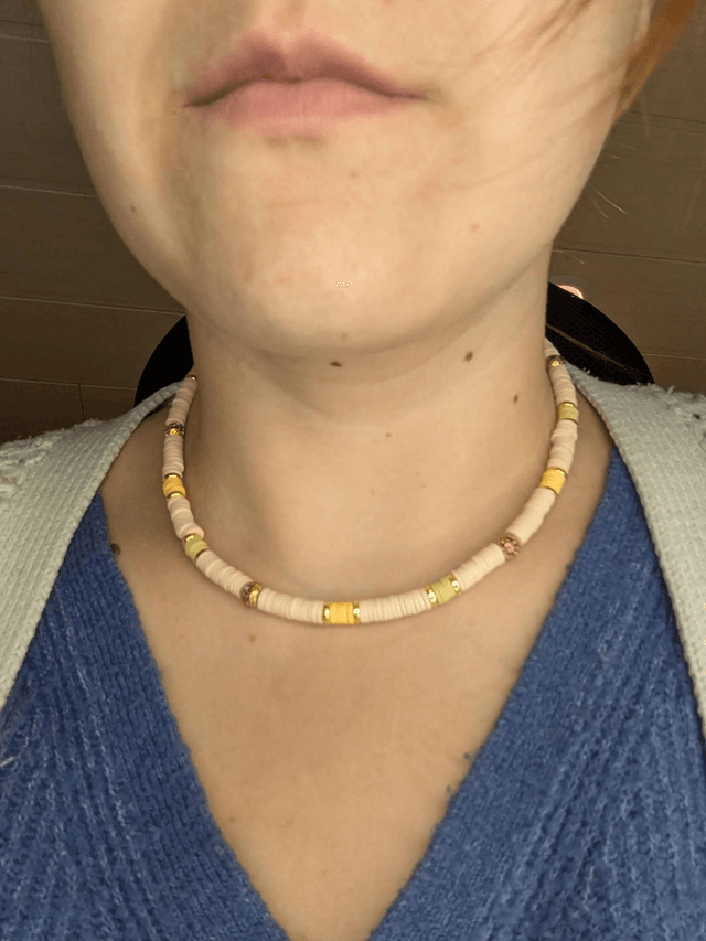 collier ras de cou avec des perles plates heishi de couleurs jaune, beige et or intercalé de perles de lave volcanique doré. 