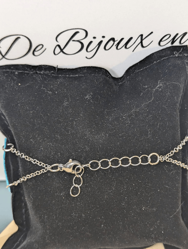 Bracelet manchette en cuir bleu, avec du tissus enduit bleu foncé (résistant), une chaine argentée. Le fermoir est de couleur argent.