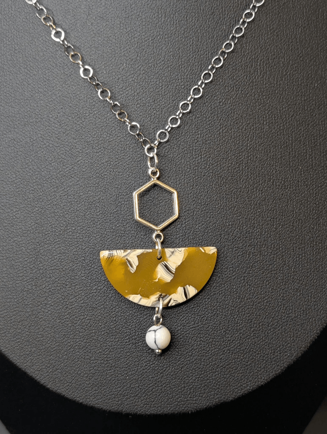 Collier mi long avec chaine couleur argent et pendentif en résine jaune et blanc, pendentif métal argenté. 