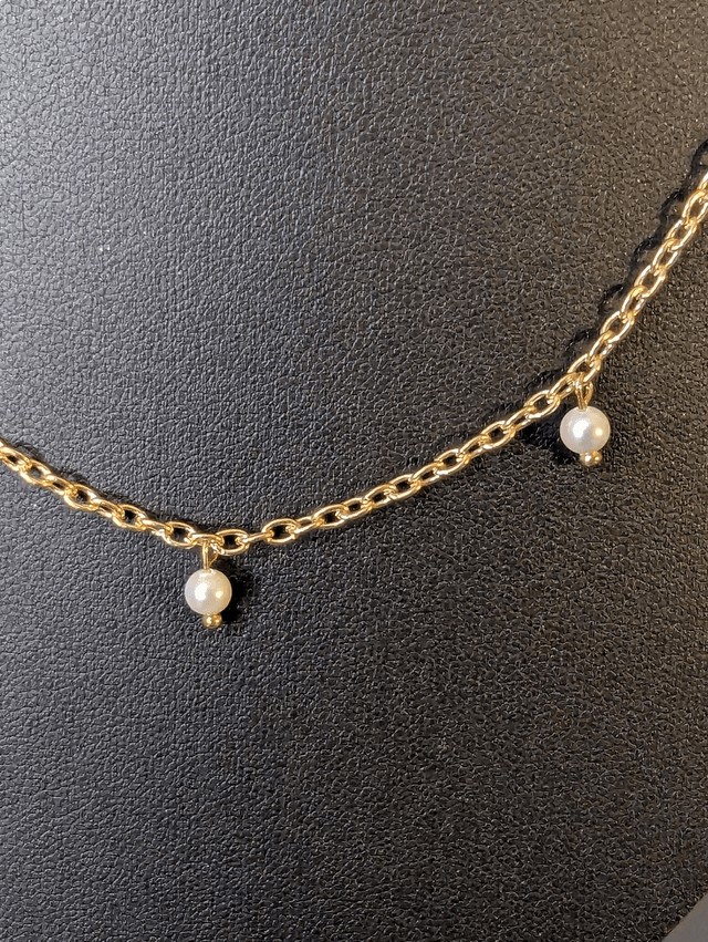 collier court avec une chaine en or fine et des perles naturelles de couleur blanc nacré, la chaine fermoir est de couleur or. 
