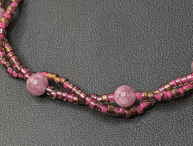 Bracelet torsadé violet avec des perles Miyuki en verre et des perles naturelles, montées sur fil de fer, le  fermoir est de couleur argent.