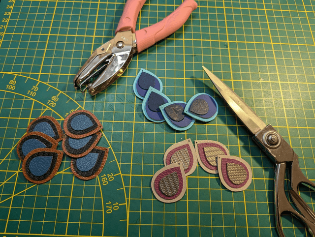 Boucles d'oreilles pendante en similicuir et en tissus enduit violet, gris argenté. avec des perles naturelles le fermoir de la boucle est en or. 
