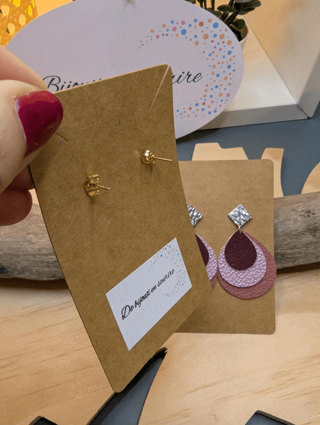 Boucles d'oreilles en cuir en forme de goutte avec un dégradé de rose/violet le derrière est en blanc. Le fermoir en clou carré est de couleur doré.