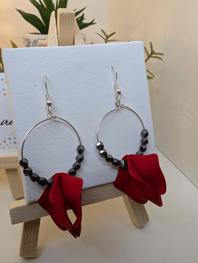 Boucle d'oreille en perles naturelles d'hématite noire et des breloque en forme de pétales en acrylique rouge. 