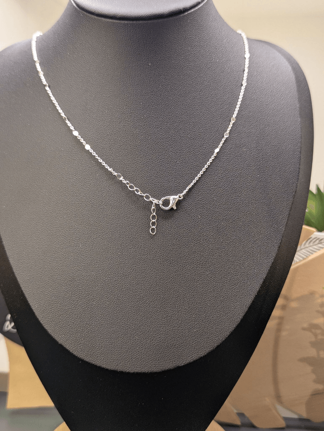 Collier avec une chaine de couleur argent et pendentif en résine en forme de cœur. 