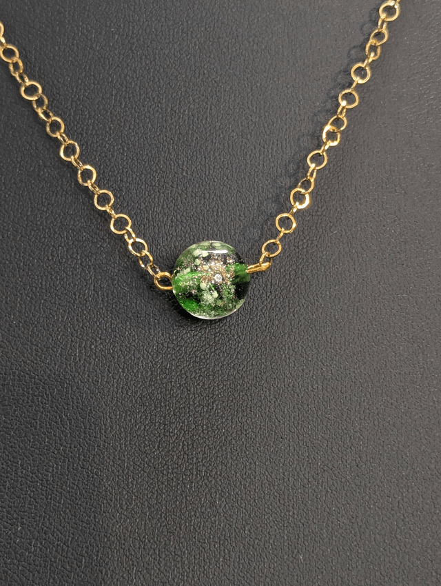 collier mi long avec chaine de couleur or et pendentif en verre de couleur vert foncé. 