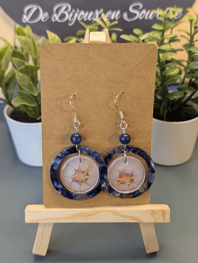 Boucles d'oreilles avec 2 pendentifs ronds, des perles naturelles et un fermoir couleur argent. 