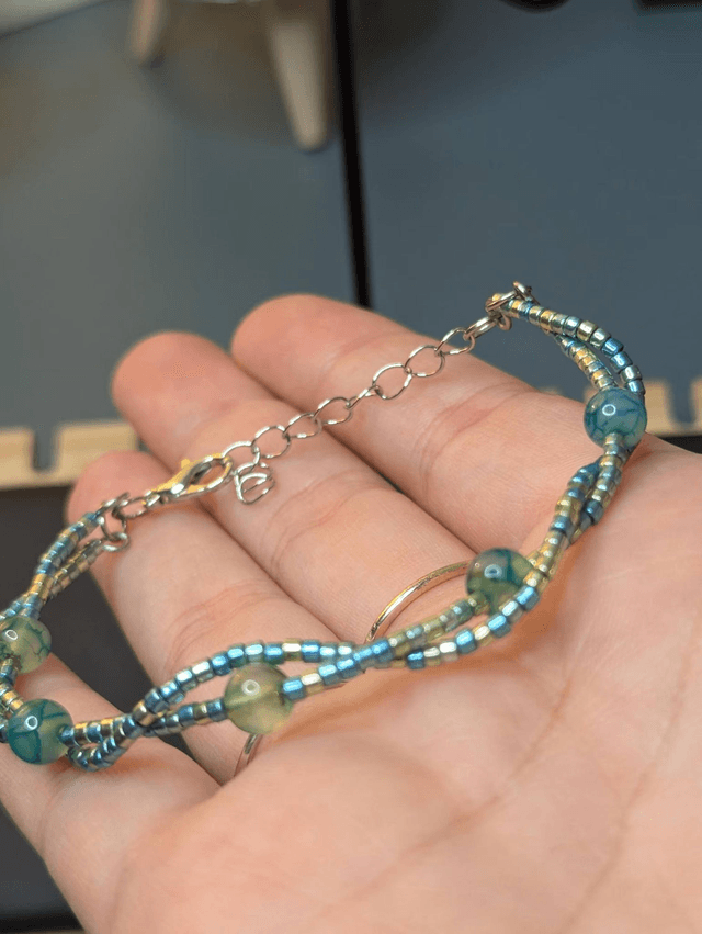 Bracelet torsadé vert avec des perles de  Miyuki en verre et des perles naturelles, montées sur fil de fer. Le fermoir est en couleur argenté.