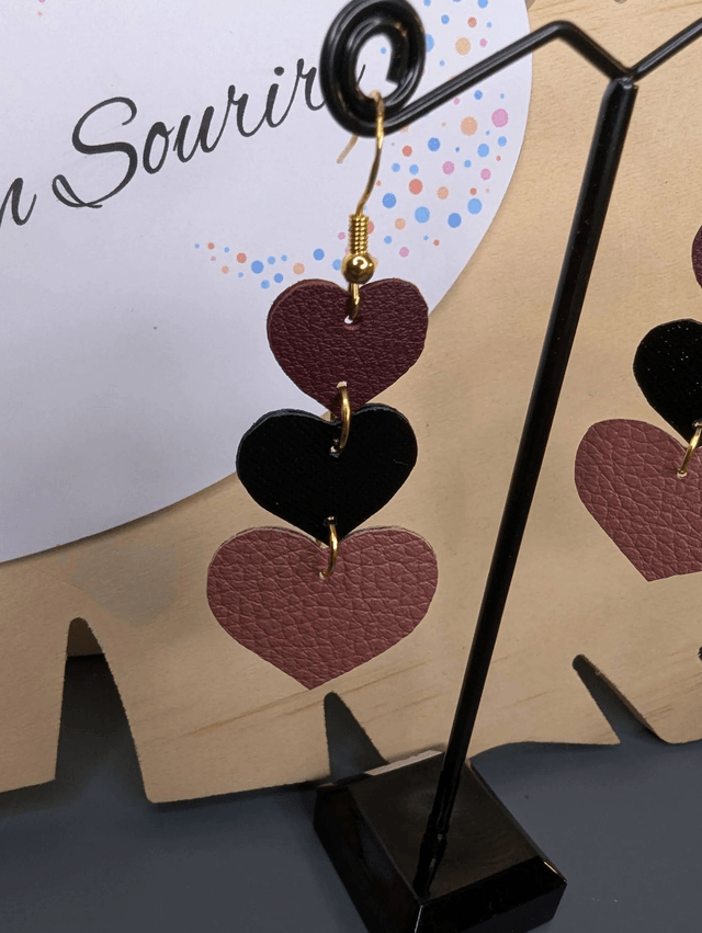 Boucles d'oreilles double face, en forme de cœur, avec du cuir véritable rose et noir texturé, le fermoir est de couleur or hypoallergénique. 