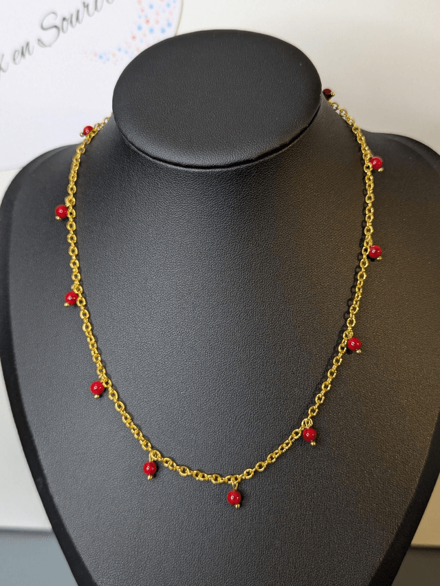 collier court chaine en or fine et des perles naturelles de couleur rouge, la chaine fermoir est de couleur or. 