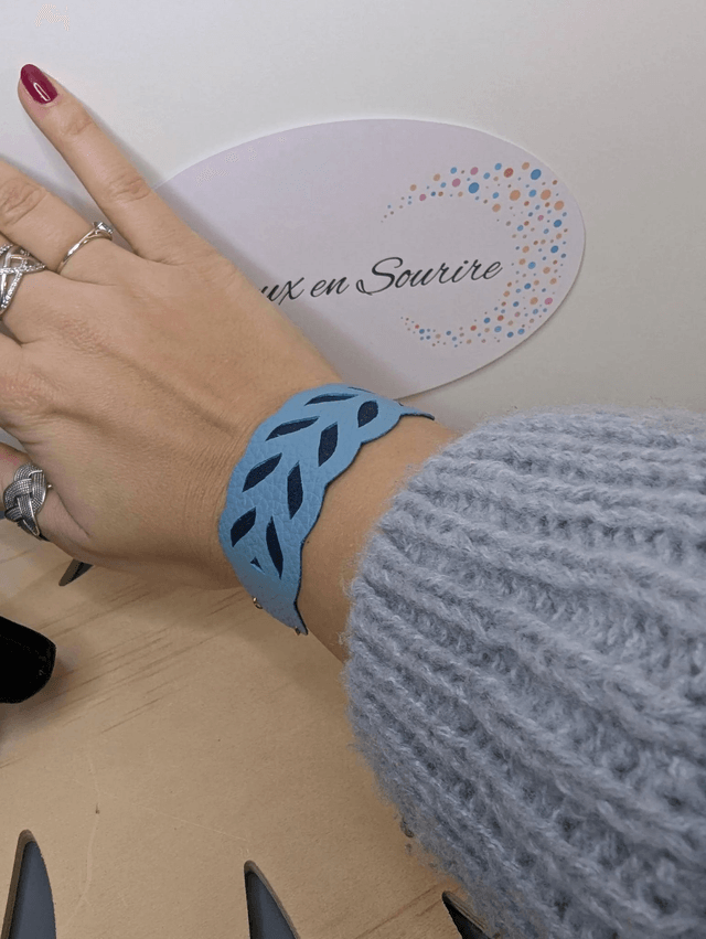 Bracelet manchette en cuir bleu, avec du tissus enduit bleu foncé (résistant), une chaine dorée. Le fermoir est de couleur doré.