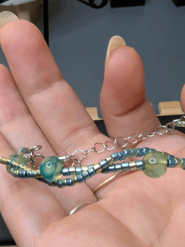 Bracelet torsadé vert avec des perles de  Miyuki en verre et des perles naturelles, montées sur fil de fer. Le fermoir est en couleur argenté.