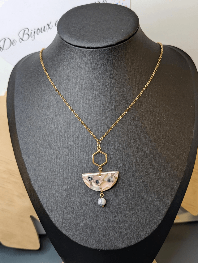Collier mi long avec une chaine de couleur or et un pendentif en résine rose et noir et un pendentif en métal doré.