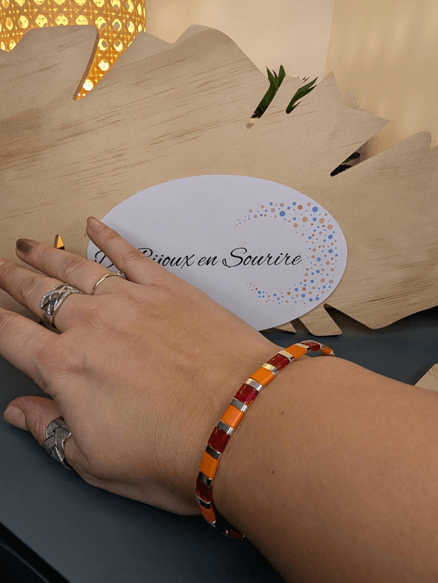 Bracelet en perles plate en verre orange et rouge, perles en métal argenté. le fermoir et la chaine fermoir sont en argent.