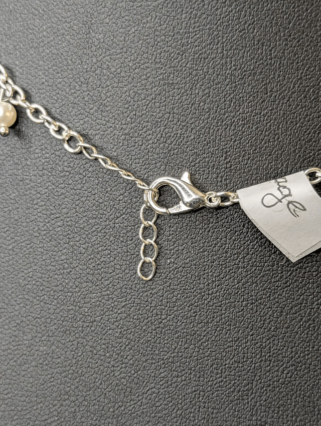 collier court avec une chaine en argent fine et des perles naturelles de coquillage blanc, la chaine fermoir est de couleur argenté. 