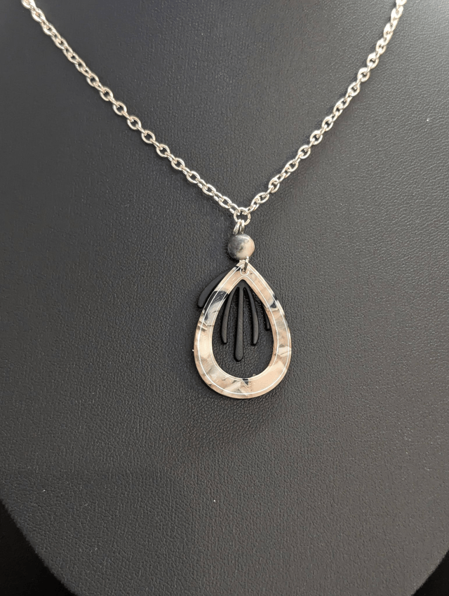 Collier mi long avec chaine couleur argent et deux pendentifs rose et noir et perles naturelle. 
