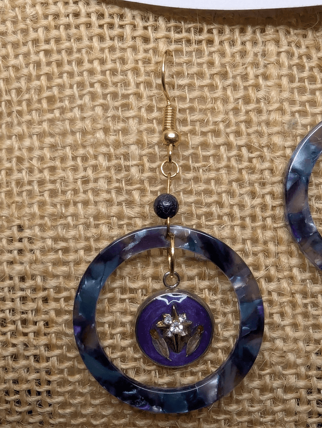 Boucles d'oreilles avec 2 pendentifs, cercle en résine coloré bleu violet, avec des fleurs séchées, des perles naturelle et un fermoir en or. 