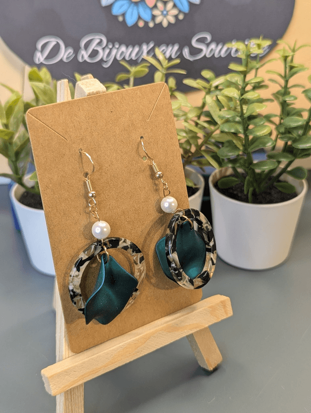 Boucles d'oreilles avec 2 pendentifs, cercle en résine coloré blanc et noir et pétale vert à l'intérieur.