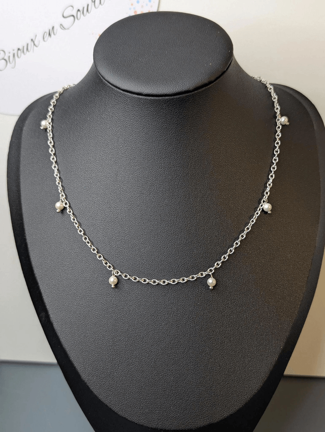 collier court avec une chaine en argent fine et des perles naturelles de coquillage blanc, la chaine fermoir est de couleur argenté. 