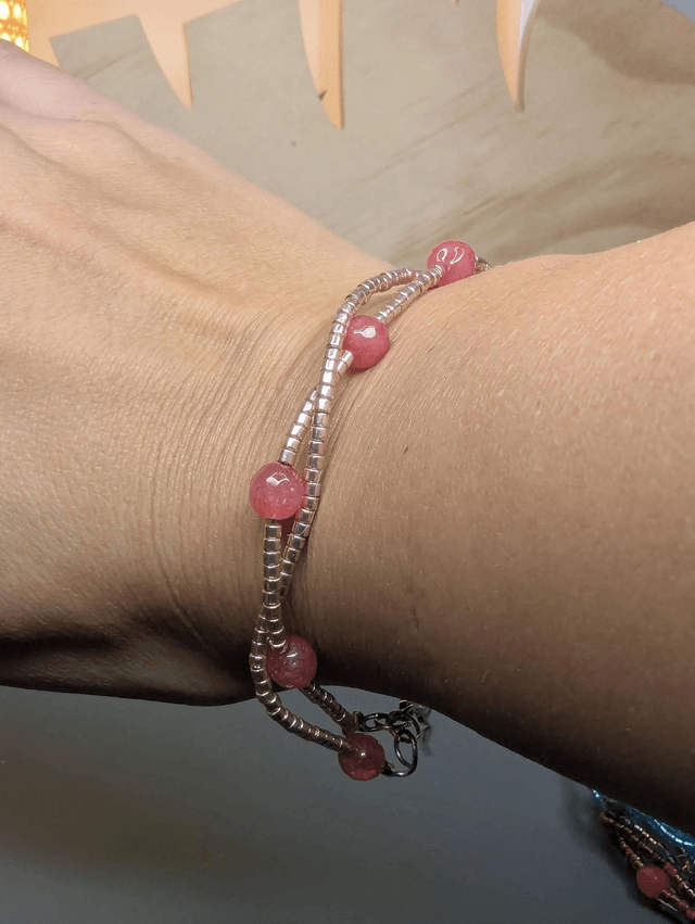 Bracelet torsadé rose métallisé, avec des perles Miyuki en verre et des perles naturelles sur fil de fer. Le fermoir est de couleur argent.