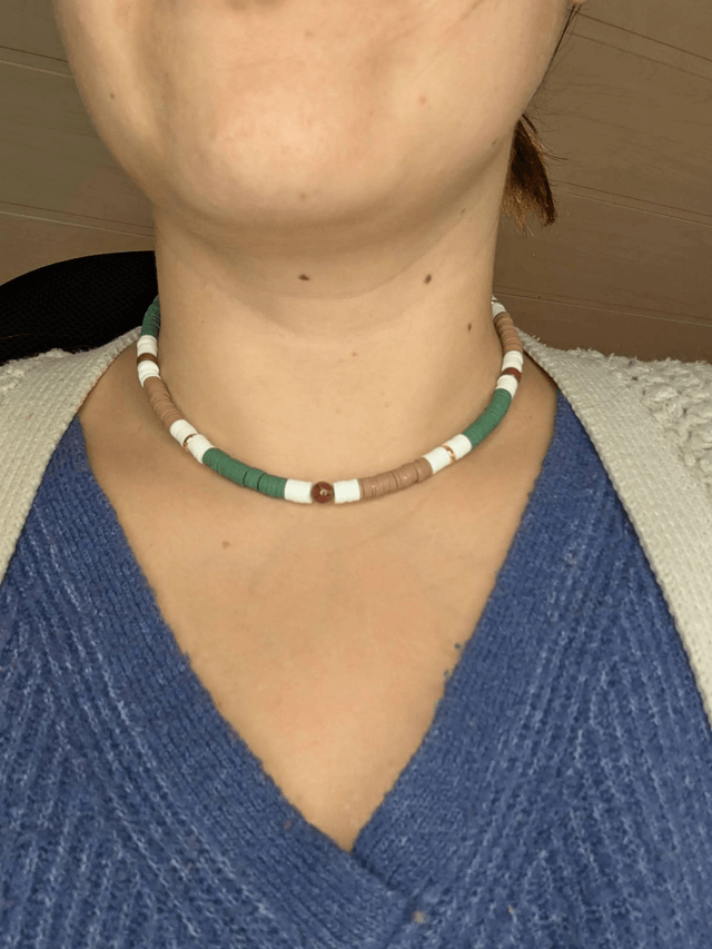 collier ras de cou avec des perles plates heishi de couleurs vert, blanc, marron et or et des perles naturelles.