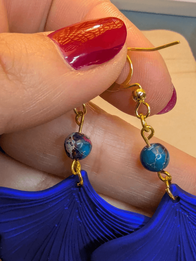Boucles d'oreilles avec pendentifs en forme de feuilles de couleur bleu métallisé avec des perles de jaspe sédiment de mer.