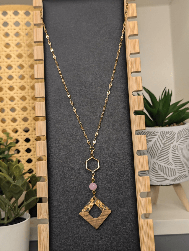 Collier long, sautoir, avec une chaine de couleur or, des perles naturelles, un pendentif en métal et pendentif en bois.