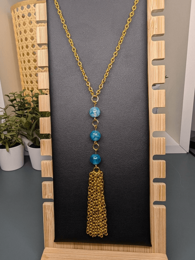 Collier long, sautoir, chaine de couleur or, avec des perles naturelles d'agate bleu-vert et un pompon en chaine doré.