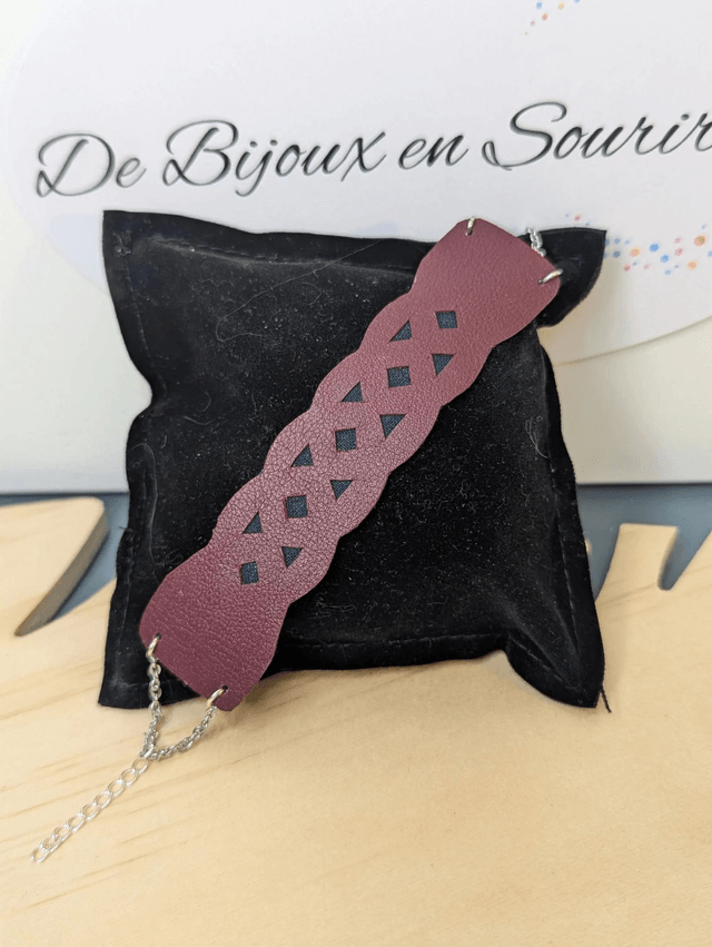 Bracelet manchette en cuir rouge Bordeau, avec du tissus enduit noir (résistant), une chaine couleur argent. le fermoir est de couleur argent.