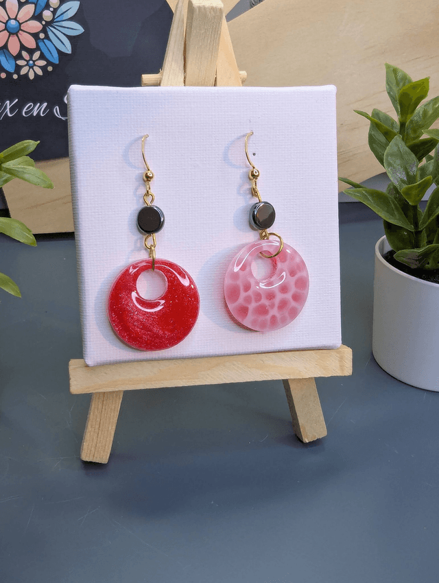 Boucles d'oreilles ronde en résine UV rose et hématite. 