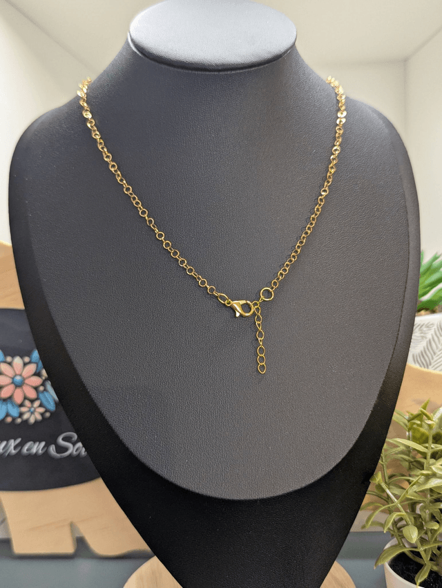 collier mi long avec chaine de couleur or et pendentif en verre de couleur vert foncé. 