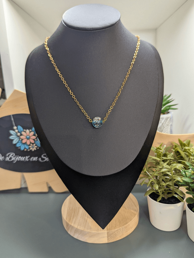 collier mi long avec chaine de couleur or et pendentif en verre de couleur bleu foncé.