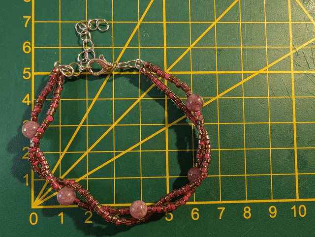 Bracelet torsadé violet avec des perles Miyuki en verre et des perles naturelles, montées sur fil de fer, le  fermoir est de couleur argent.