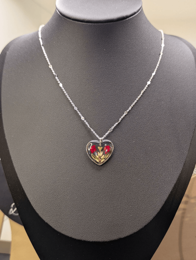 Collier avec une chaine de couleur argent et pendentif en résine en forme de cœur. 