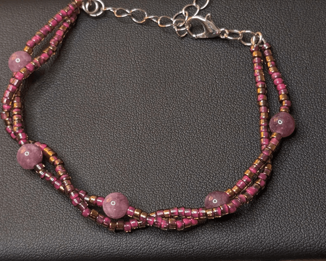Bracelet torsadé violet avec des perles Miyuki en verre et des perles naturelles, montées sur fil de fer, le  fermoir est de couleur argent.