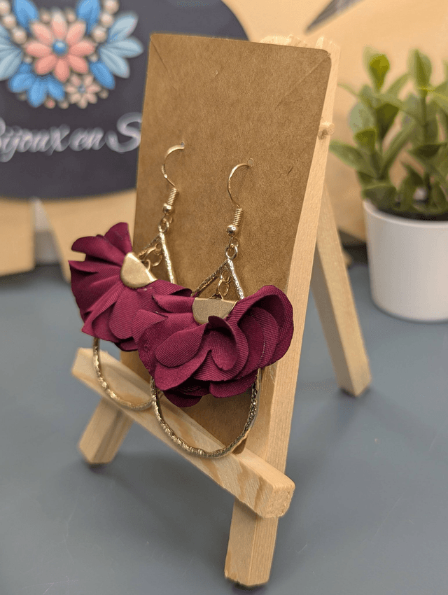 Boucles d'oreilles en forme de goutte doré avec pompon plat bordeaux et fermoir doré. 