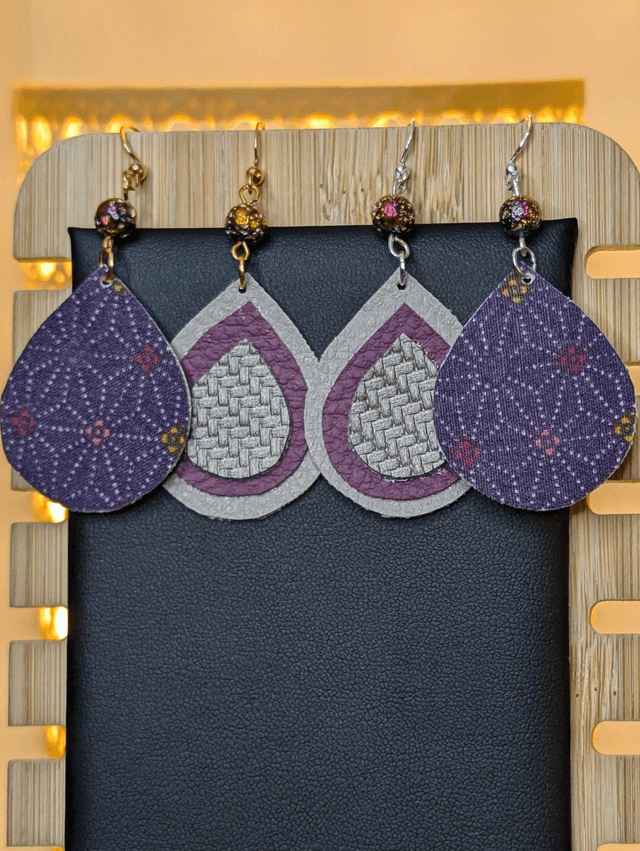Boucles d'oreilles pendante en similicuir et en tissus enduit violet, gris argenté. avec des perles naturelles le fermoir de la boucle est en or. 