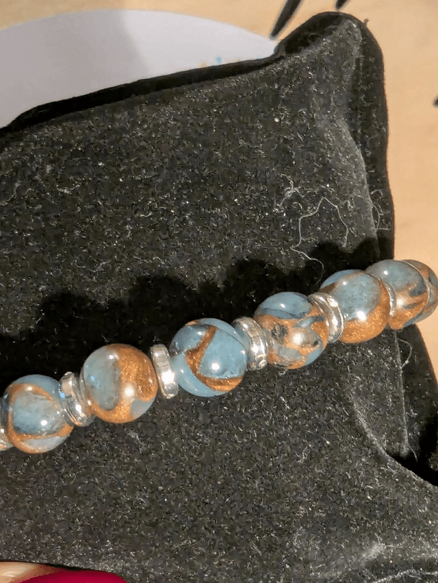 Bracelet perles d'éverisonne bleu marron perles d'espacement plate. Le fermoir et la chaine fermoir sont argent. 