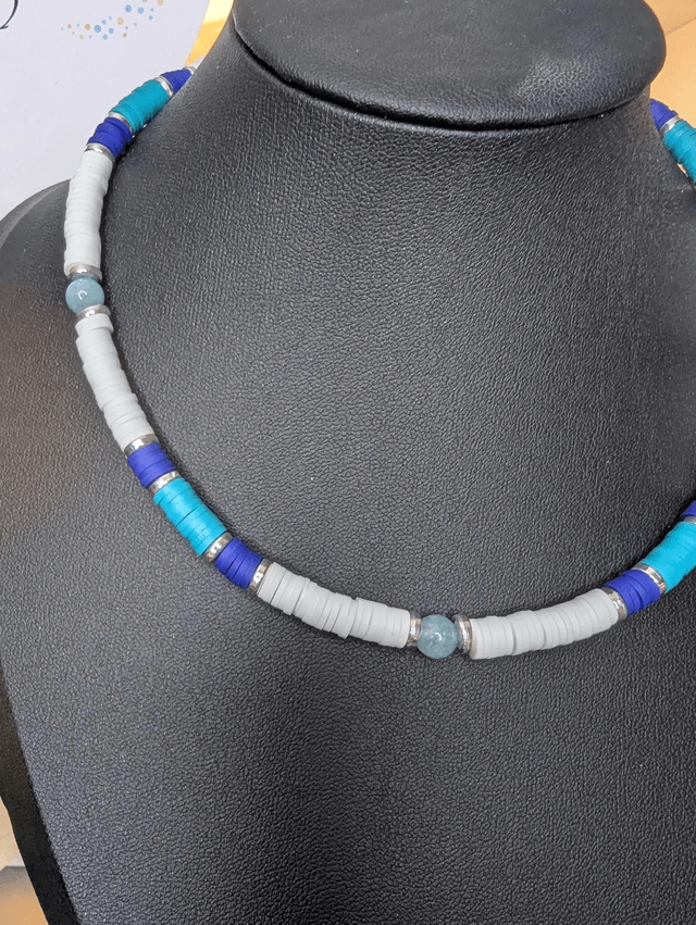 collier ras de cou avec des perles plates heishi de couleurs bleu, blanc et argenté intercalé de perles naturelles d'aigue marine. 