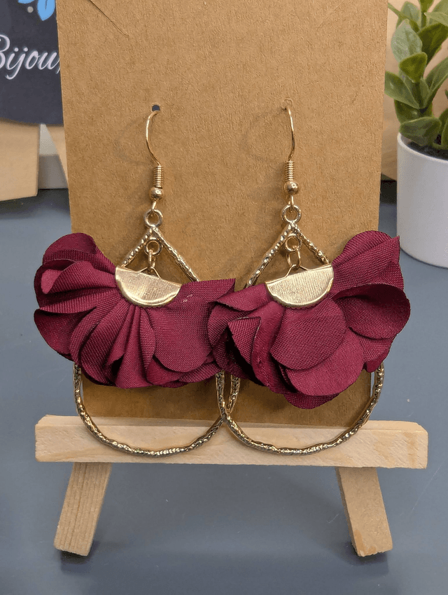 Boucles d'oreilles en forme de goutte doré avec pompon plat bordeaux et fermoir doré. 