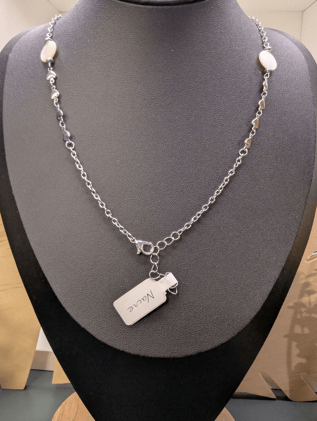Collier mi long avec deux chaines de couleurs argent, des perles de nacre et un pendentif en résine avec fleurs séchés. 