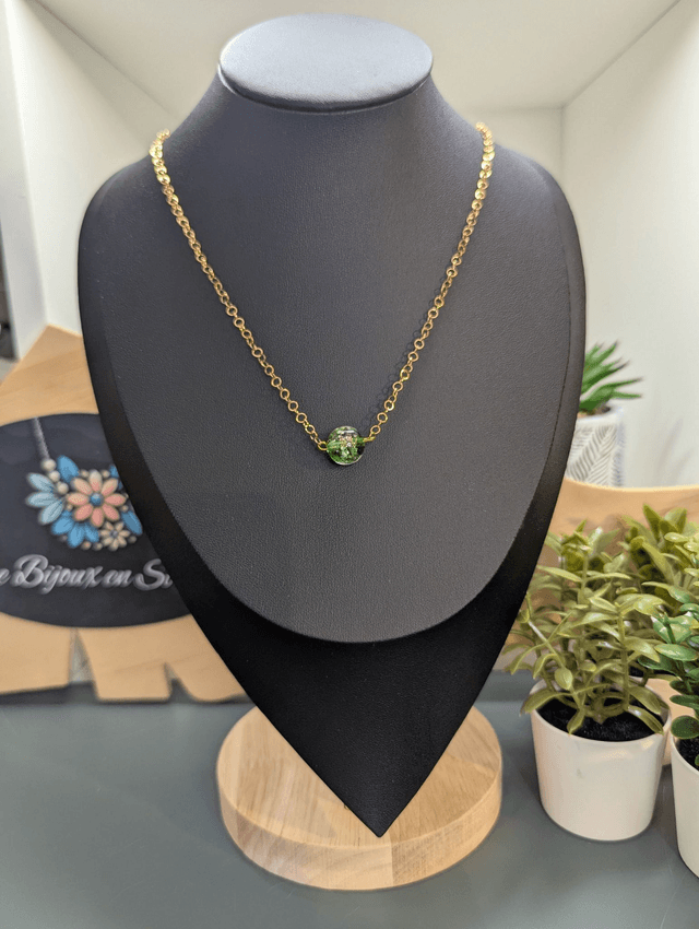 collier mi long avec chaine de couleur or et pendentif en verre de couleur vert foncé. 