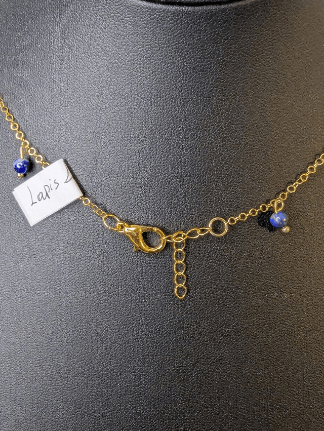 collier court avec une chaine en or fine et des perles naturelles de couleur bleu, la chaine fermoir est de couleur or. 
