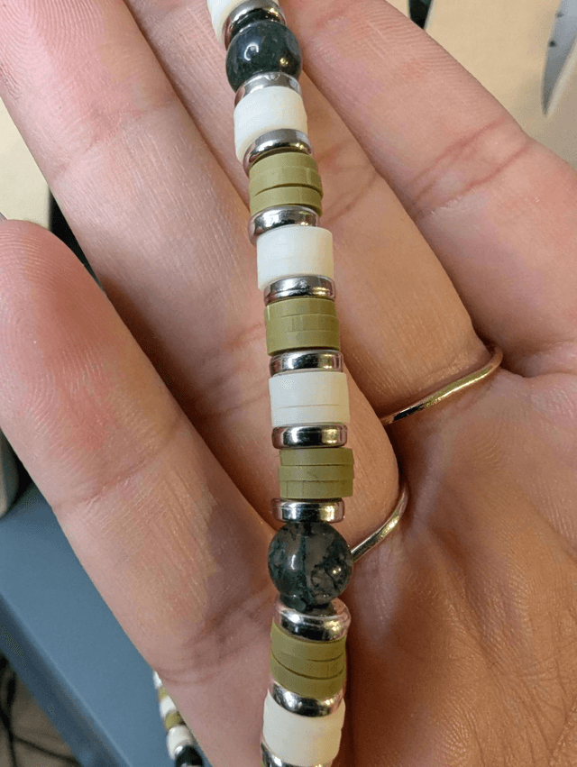 collier ras de cou avec des perles plates heishi de couleurs vert, blanc et argent intercalé de perles naturelles d'agate mousse. 